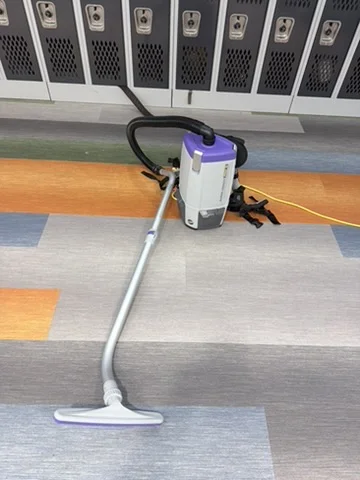 Backpack vacuum and wand on commercial carpet
